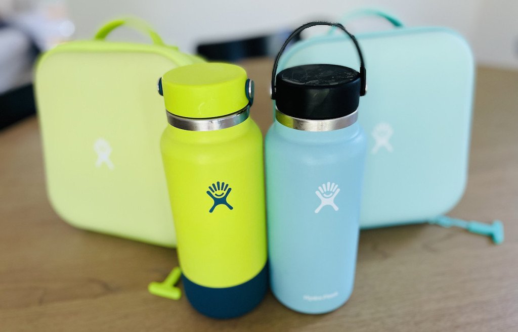 green and blue hydro flask water bottle on table with lunchboxes